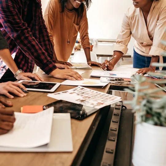 A team planning around a table covered in documents